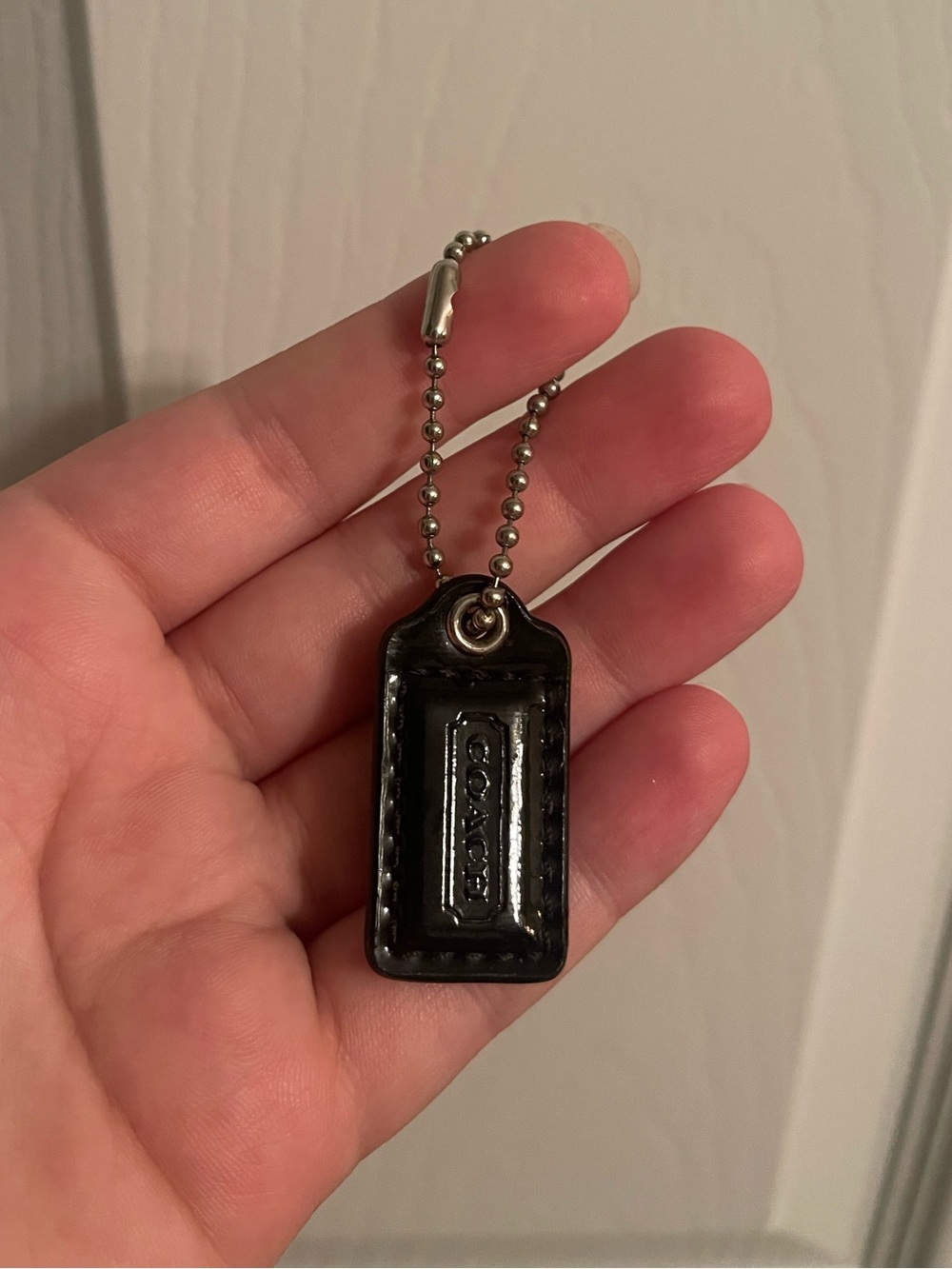 29. Coach black patent leather hang tag
